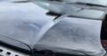 ヘッドライトやフロントグリルが映る、カーコーティング後の黒い車のボンネット部分の光沢感